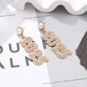 Macro shot of long drop earrings with 2025 pearl rhinestone numbers and luxury studs
