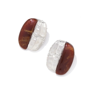 Detailed shot of amber resin and silver textured metal oval earrings in retro style