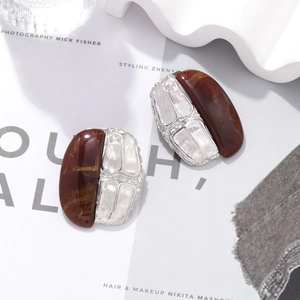 Detail of vintage oval earrings with amber resin and white shell texture panels