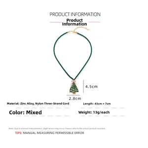 Detail of enamel Christmas tree pendant with pink bow on green rope chain