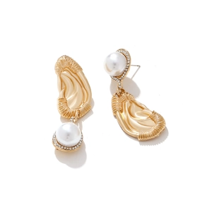 Vintage gold textured metal earrings with pearls and crystal accents on white background