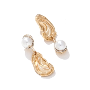 Detail of long gold drop earrings with white pearls and sparkling rhinestone accents
