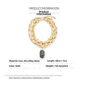 Detail of chunky gold chain necklace with marble resin stone pendant and 40cm length