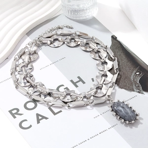 Macro view of silver chunky chain necklace with grey marble stone pendant and claw setting