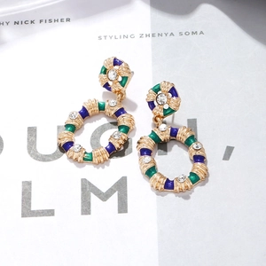 Vue macro des boucles d'oreilles vintage en alliage doré avec émail bleu-vert et strass