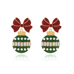 Dettaglio orecchini di Natale con fiocco rosso e palla da discoteca verde