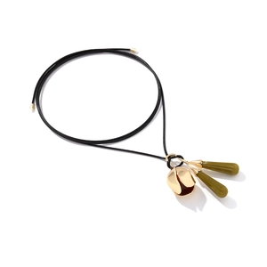Close-up of vintage resin flower pendant with golden bud on a black cord necklace