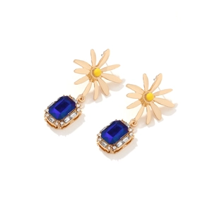 Detailed macro view of daisy earrings with blue crystal drop and sparkling rhinestones