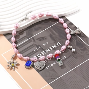 Elegant beaded necklace with pink baroque pearls, daisy charms, and a heart pendant