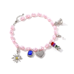 Pink pearl necklace with heart, cat, and flower charms on a clean white background