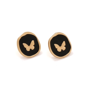 Detailed macro view of vintage butterfly studs with gold metal and black enamel finish