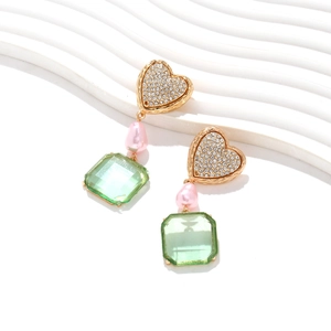 Detail of drop earrings with pink pearl and green crystal in gold setting