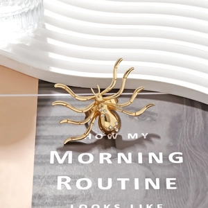 Gold spider ring with sparkling crystals on white tray with a modern stylish background