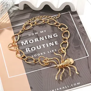Bold gold chain necklace featuring a crystal-encrusted spider pendant on a white background