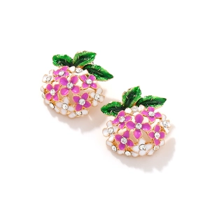 Macro detail of enamel flower earrings with pink petals and sparkling rhinestones