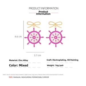 Detail view of purple enamel nautical helm earrings with gold bow and size measurements