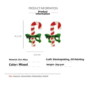 Detail view of Christmas candy cane earrings with green bows and size measurements
