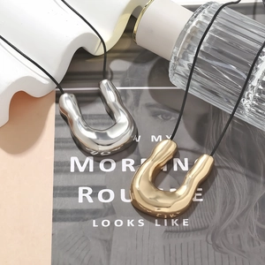 Minimalist U-shaped liquid metal pendant necklaces in gold and silver finish with black cord
