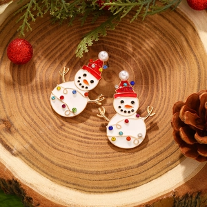 Christmas snowman earrings with colorful rhinestones and pearls on wood background