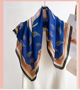Close-up of royal blue silk scarf with golden chain and paisley pattern on hanger