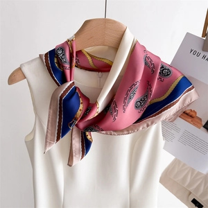 Detailed view of pink paisley silk scarf with gold patterns and navy blue border trim