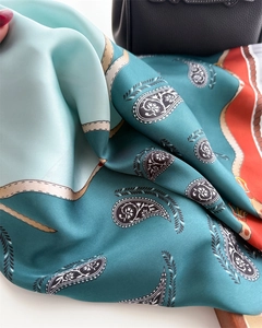 Detailed view of the paisley silk scarf's intricate patterns and smooth texture