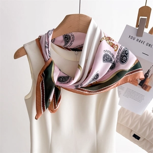 Detailed view of square silk scarf with paisley pattern tied on a dress