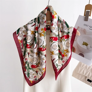 Elegant silk scarf with tropical floral print in red and green hung with a stylish handbag