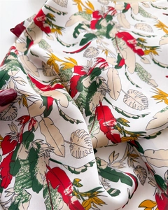 Macro shot of tropical plant print on lightweight silk-like fabric with vibrant leaves