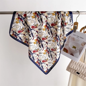 Detail of colorful feather and leaf print silk scarf with a navy blue border on display
