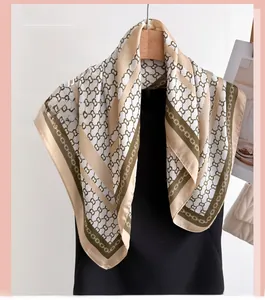 Detailed view of the smooth satin texture and luxury chain print on silk square scarf