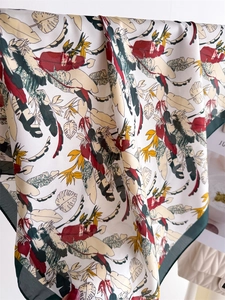 Detailed view of the tropical leaf print scarf with smooth silk-like texture and drape