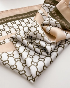 Detail of silk scarf with elegant chain pattern, ivory and olive green satin texture