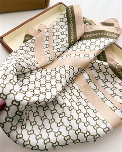 Detailed view of luxury silk scarf with plaid and chain patterns in a gift box