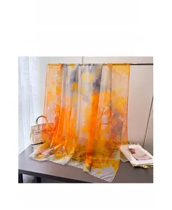 Detail of artistic orange and grey floral print on lightweight long sheer silk scarf