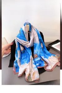 Detail of blue floral faux silk scarf with satin finish and delicate rolled edges