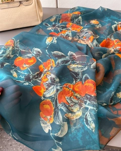 Detail of lightweight sheer emerald silk scarf featuring vintage orange fruit prints
