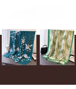 Detail of silk-like long scarves featuring elegant floral prints in green and blue tones