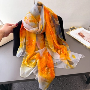 Artistic orange floral printed long chiffon scarf for women worn as sun protection shawl