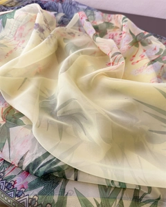Macro detail of lightweight translucent scarf with elegant pink floral print and soft folds