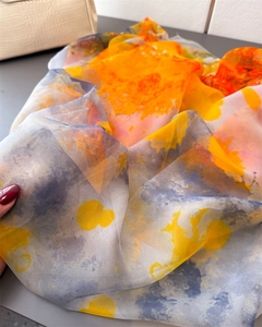 Detail of artistic orange and yellow abstract print on soft, lightweight floral shawl