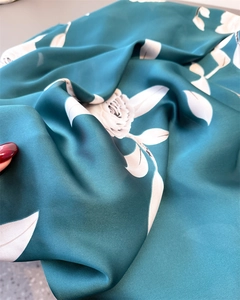 Close-up of silky lake blue floral scarf showing soft luster and detailed rose print