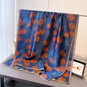 Detail of blue silk scarf with red rose pattern and smooth lightweight texture