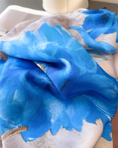 Close-up of lightweight silk shawl showing blue floral print and smooth fabric texture