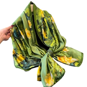 Long silk-like satin scarf featuring yellow lotus print on green background for women