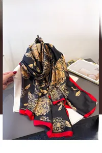 Detail of floral faux silk scarf with gold flowers on black background and red borders