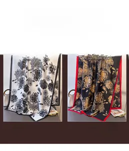 Detail view of floral satin scarves in white with black trim and black with gold patterns