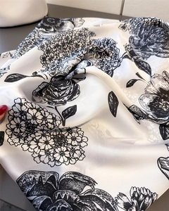 Close-up of lightweight faux silk scarf with elegant black and white floral print