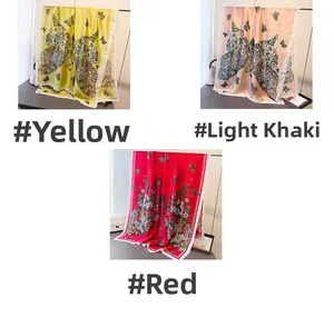 Dettaglio di foulard in seta con stampa a farfalla nei colori giallo, kaki e rosso