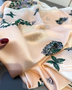 Macro del tessuto in finta seta con stampe di farfalle e fiori e consistenza liscia